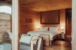 wooden interior of a cozy hotel room with a bed and lamps