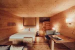 cozy wooden interior of a hotel room with a bed and seating area