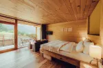 modern wooden bedroom with large windows and mountain view