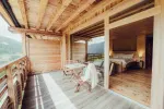 wooden balcony with furniture overlooking a scenic view