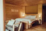 cozy wooden bedroom with bed, armchair, and soft lighting