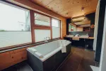 modern bathroom with a bathtub and large windows