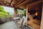 Wooden terrace with a table and chair, view of nature