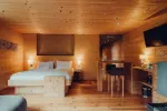 wooden bedroom with two beds, a bar area, and warm lighting