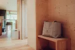 Interior of a modern space with a wooden bench and a bag on it