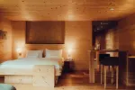 cozy wooden bedroom with a large bed and small bar area