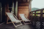 wooden balcony with two reclining chairs