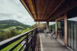 Wooden terrace overlooking green hills and cloudy sky