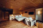 Cozy bedroom featuring a bed, armchair, and warm wooden decor