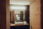 modern bathroom with sink, mirror, and wooden door