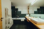 modern bathroom with a bathtub, sink, and green cabinets