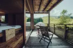 wooden balcony with chairs overlooking green landscape