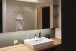 Modern bathroom with a sink, wooden countertop, and mirror