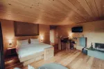 cozy bedroom with wooden accents, double bed, TV, and seating area