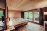 Bright, modern bedroom with wooden ceiling and large windows