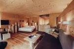 modern wooden interior of a cozy hotel room with a bed and seating area
