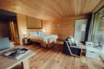interior of a cozy wooden hotel room with a bed and seating area