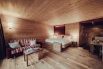 Cozy wooden room with a bed, couch, and table