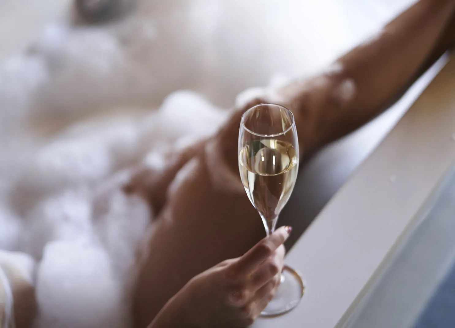 Frau genießt Sekt in der Badewanne