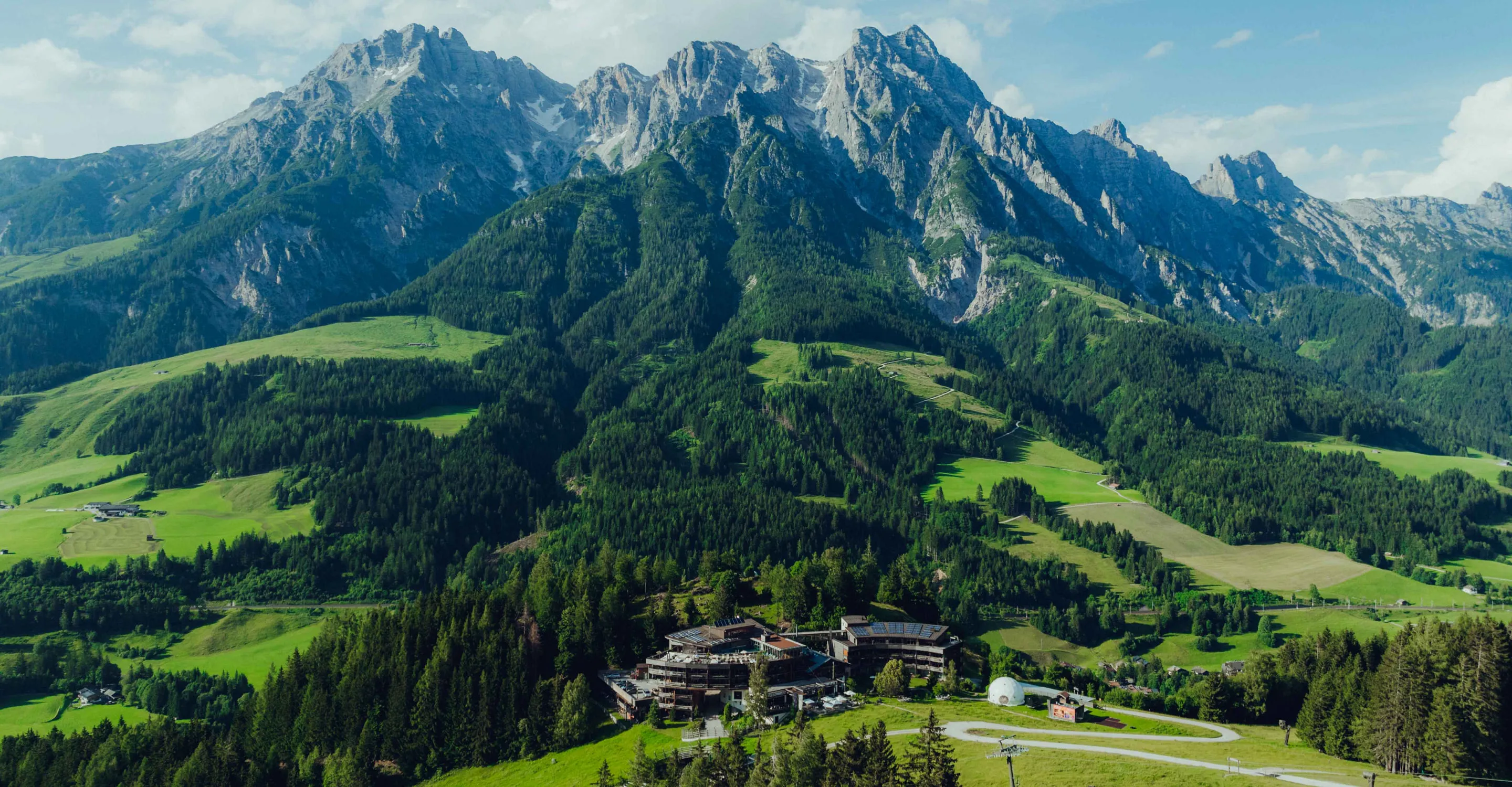 View of mountains and green valleys with a settlement in the foreground