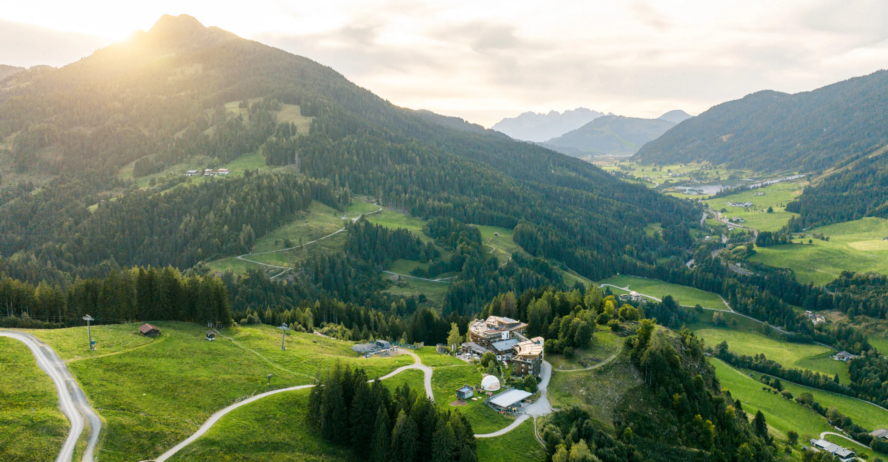 View of green hills and mountains with a village in the valley.