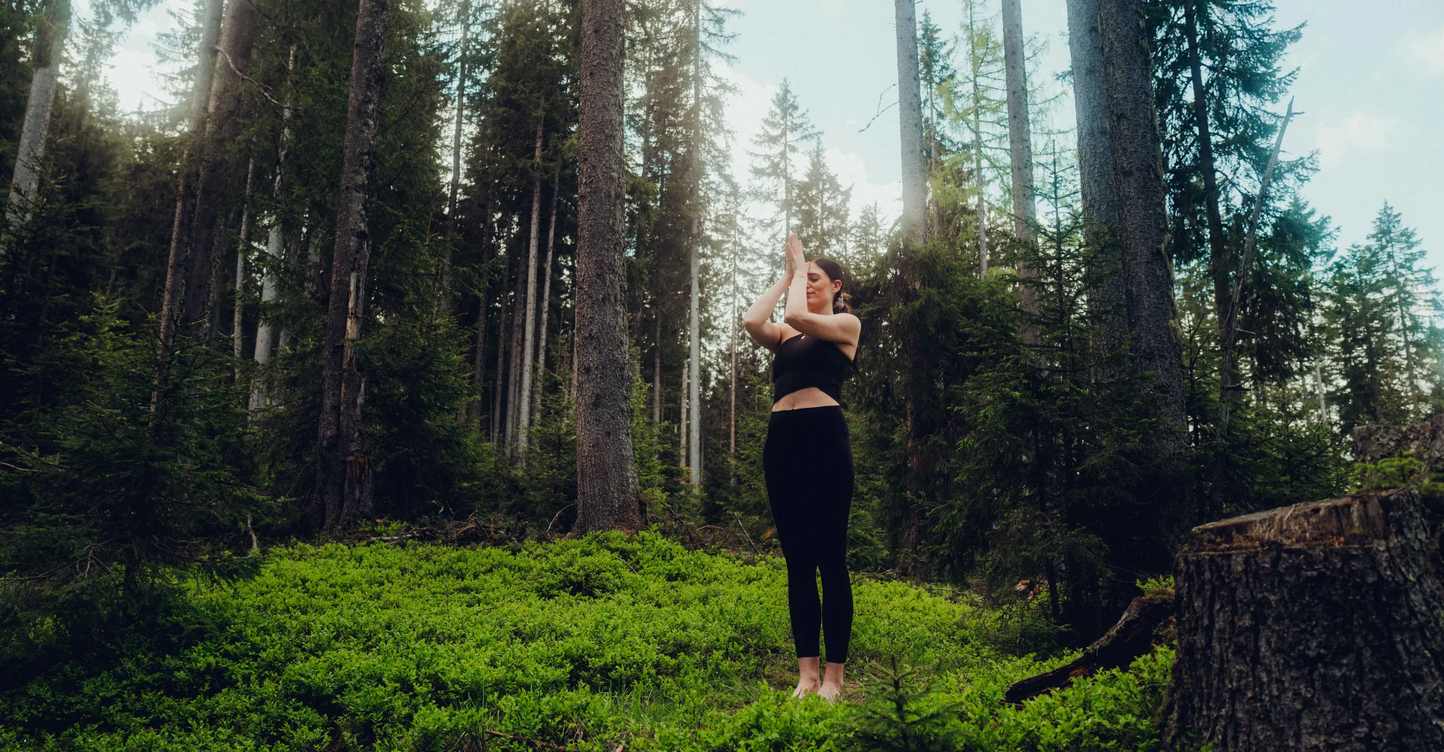 Frau macht Yoga im Wald