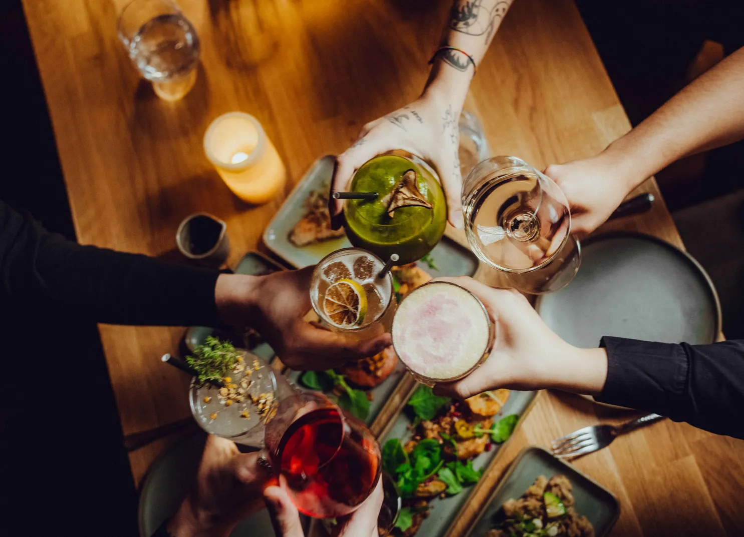 Menschen stoßen mit Getränken an