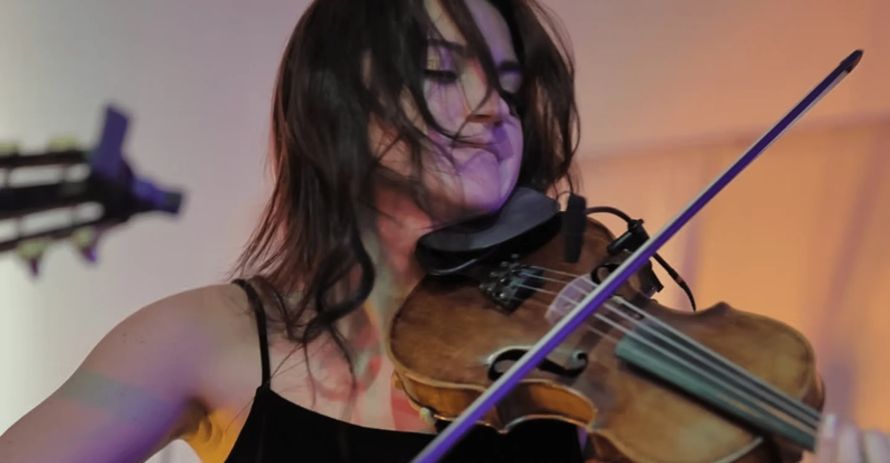 woman playing violin passionately on stage