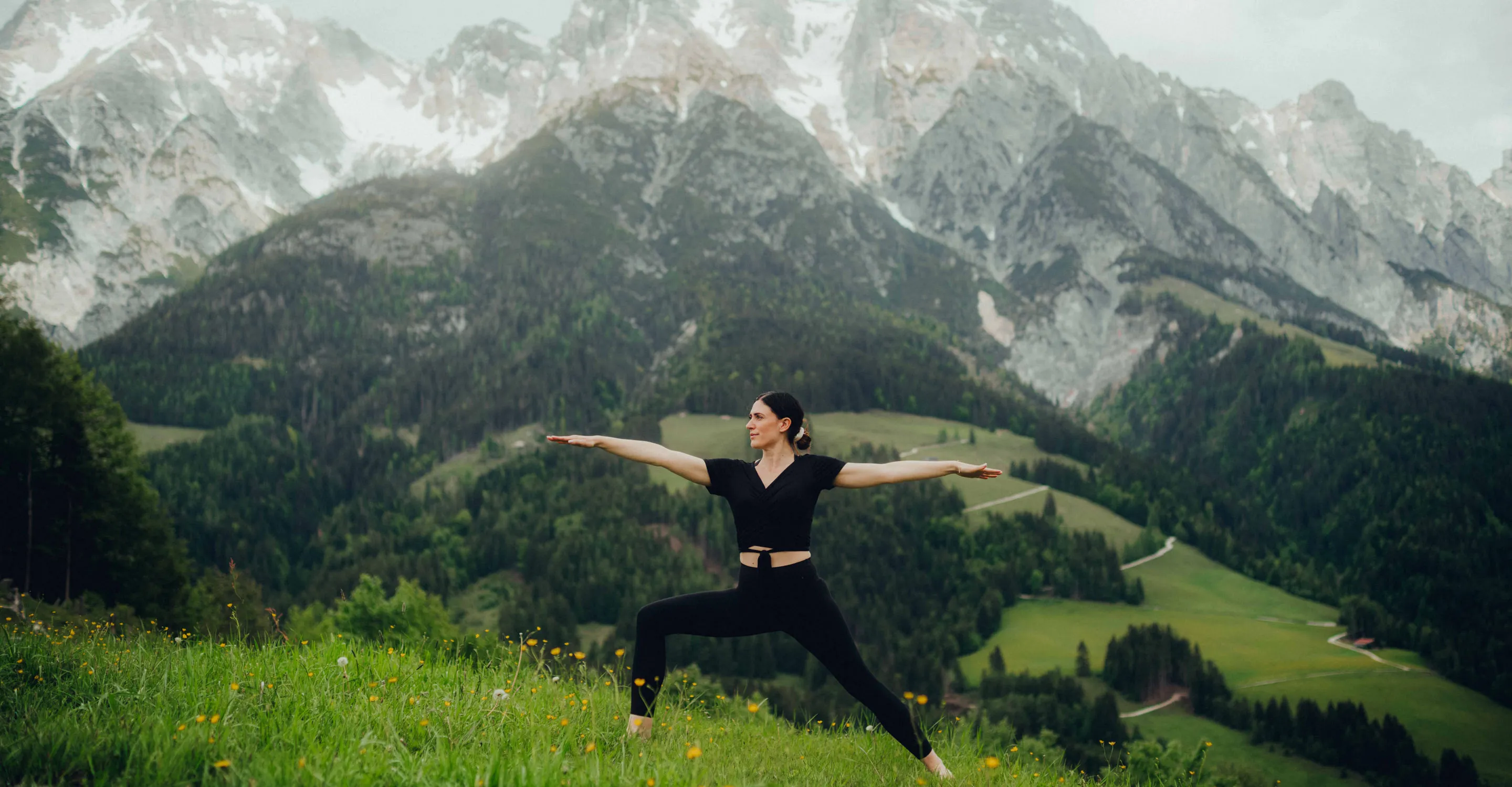 Woman in yoga pose against mountainous landscape
