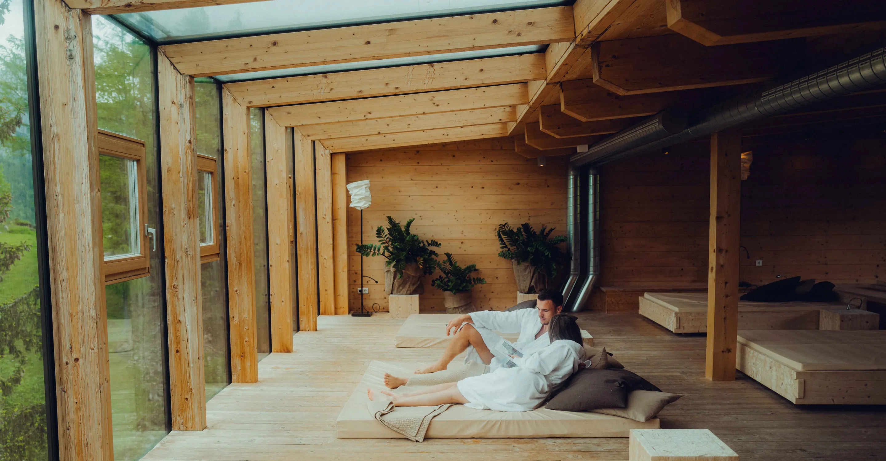 Relaxation area in Holzhotel Forsthofalm, Leogang, featuring wooden decor and views.