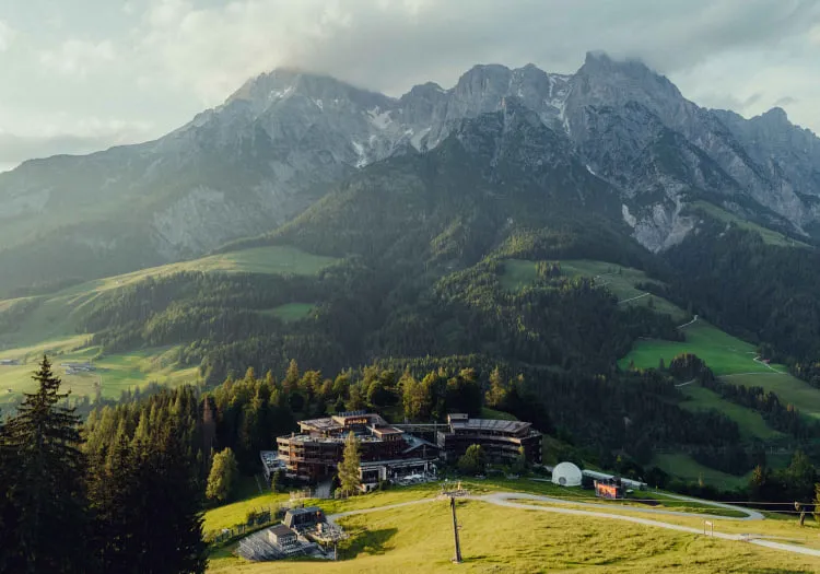 Holzhotel Forsthofalm mit Berglandschaft in Leogang