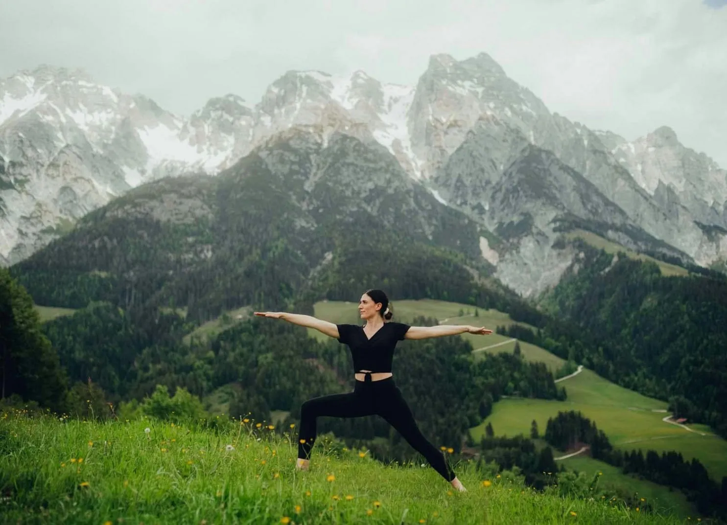Woman in activewear practicing yoga poses with mountains in background